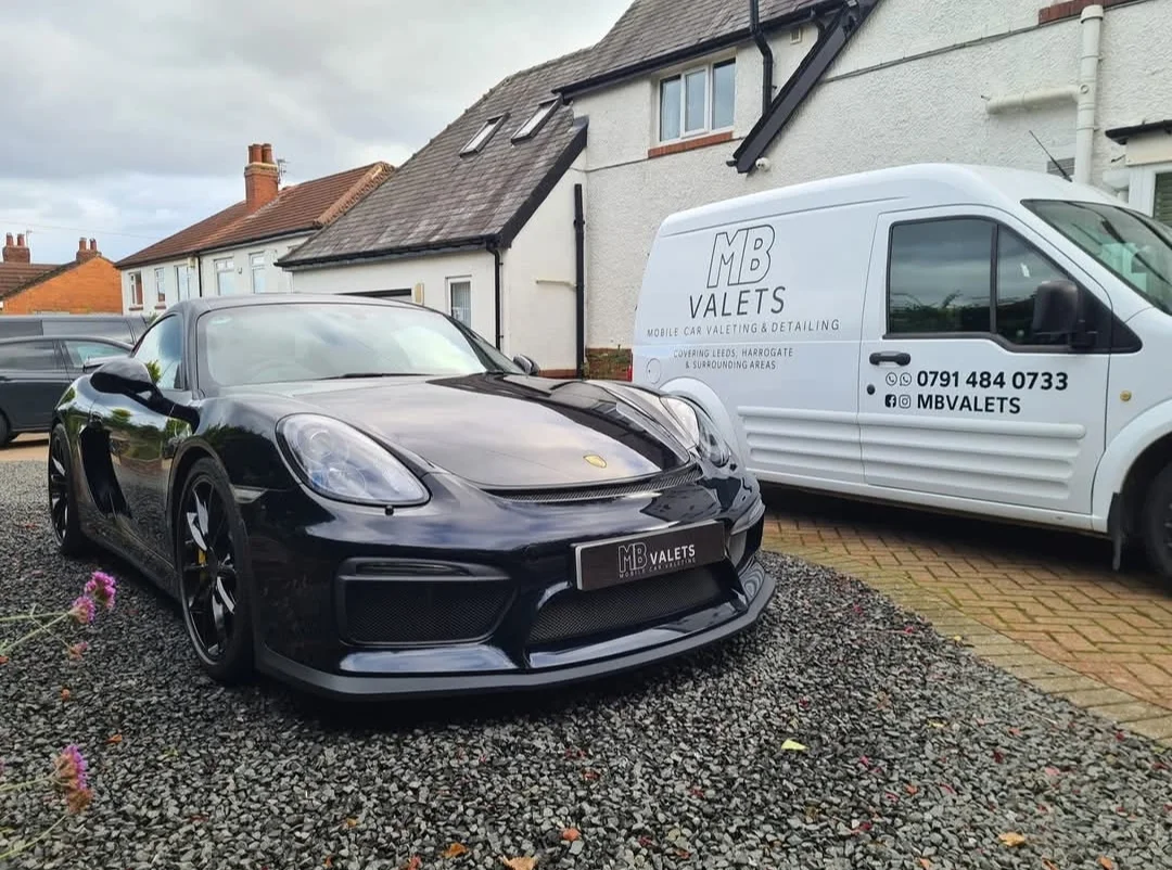 A freshly valeted black Porsche beside the MB Valets mobile van