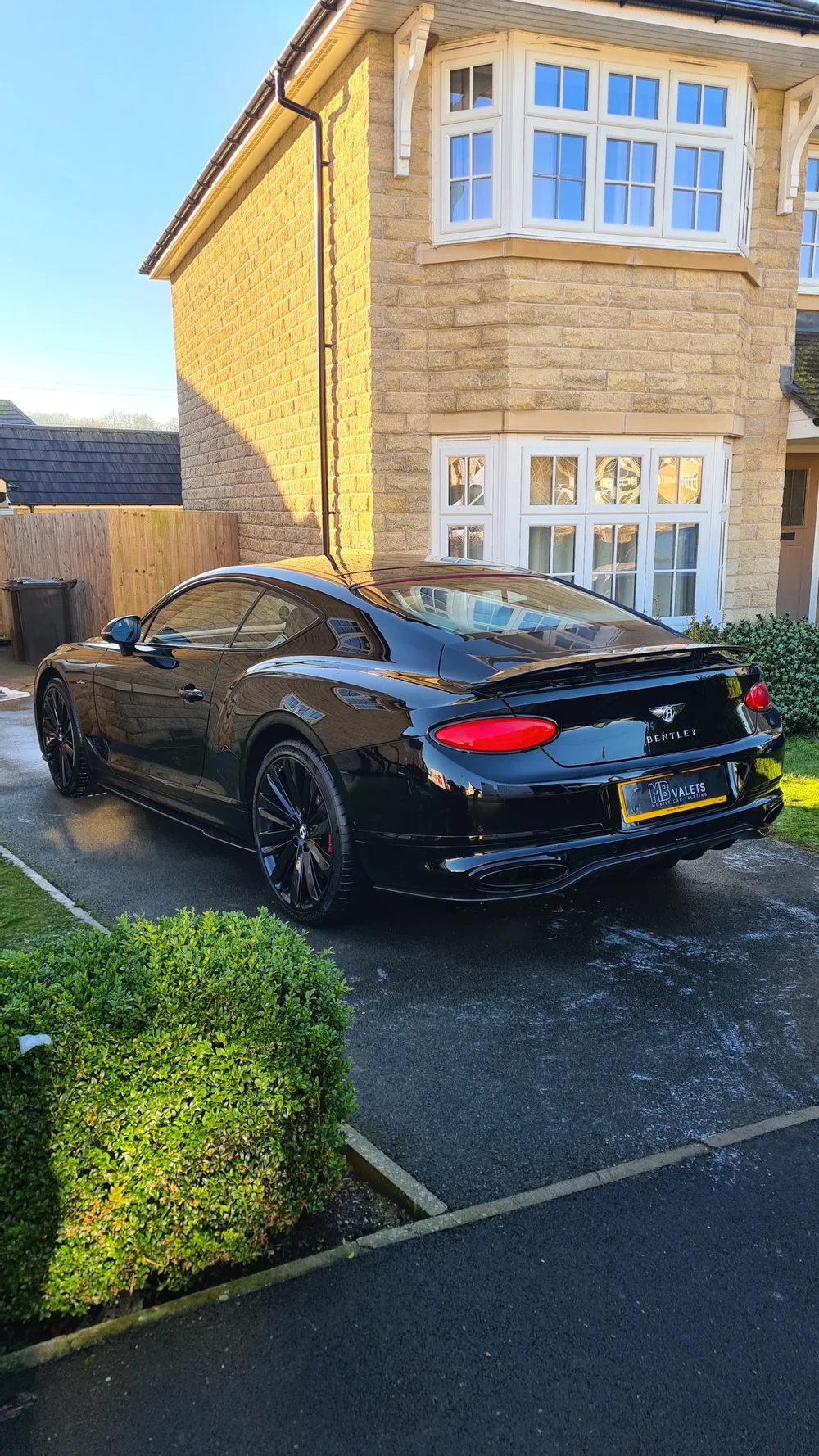 Dark sports coupe with a clean glossy finish on a driveway