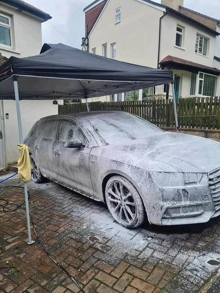 A car being carefully washed beneath the mobile valeting gazebo